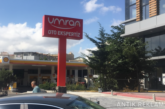 Umran Oto Ekspertiz tek bacaklı totem tabela kırmızı zemin beyaz logo yol kenarı dış mekan uygulaması