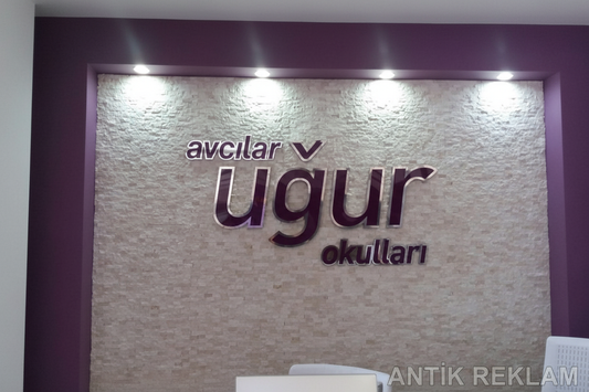 Avcılar Uğur Okulları 3D harf duvar tabela spotlu aydınlatma taş doku zemin iç mekan uygulaması
